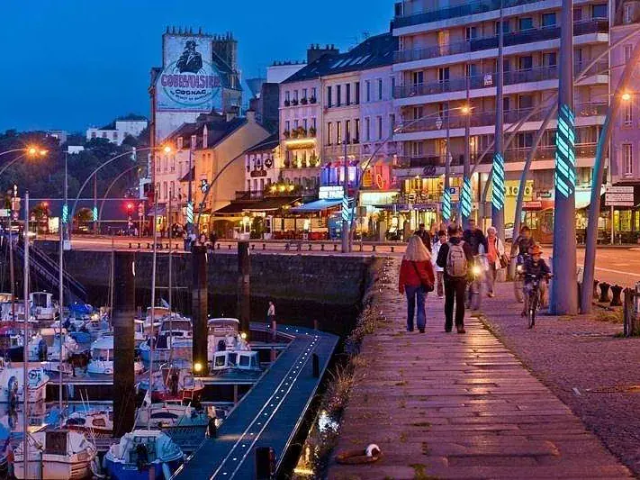 Quai animé et port de plaisance illuminé la nuit à Cherbourg
